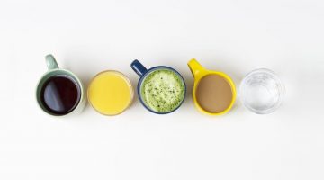 coffee tea and other drinks in colorful cups on a white background top view